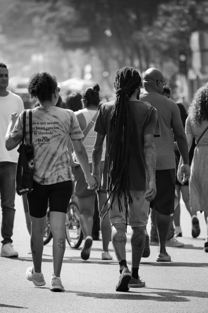 couple walking in urban street crowd b w