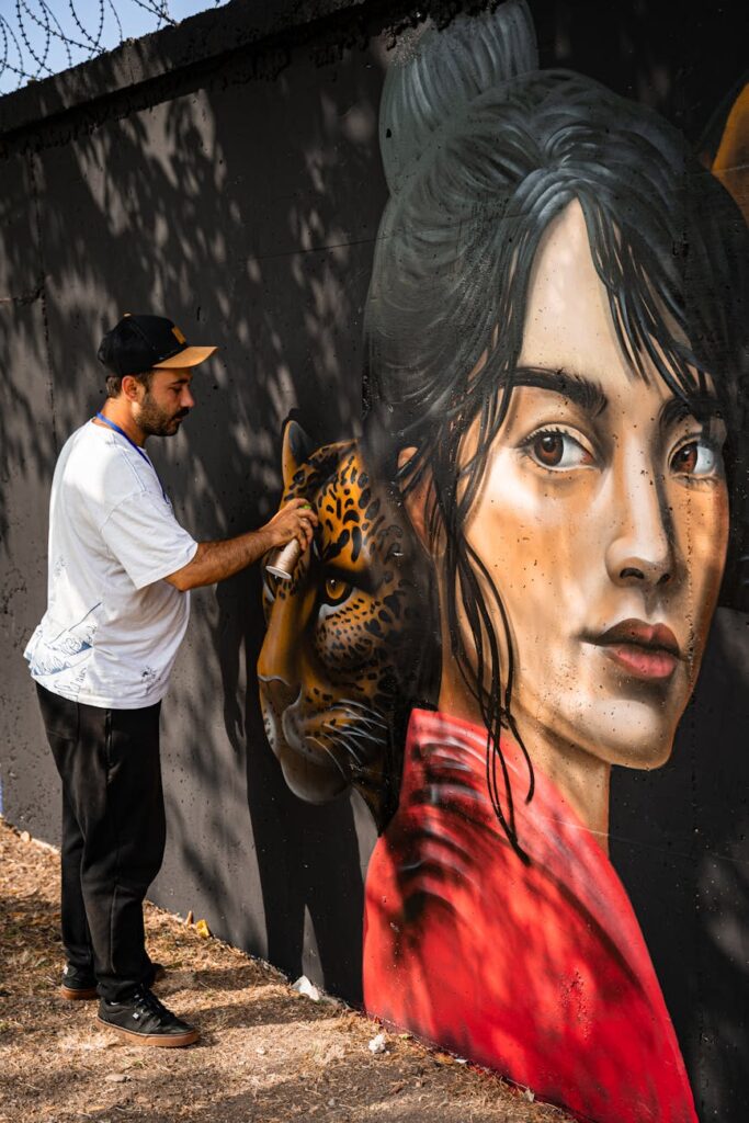 artist painting vivid street art on urban wall